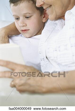 Boy reading book with grandmother View Large Photo Image Stock Photo - Boy reading book with grandmother. Fotosearch