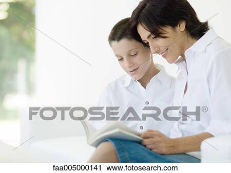 Boy reading book with mature woman View Large Photo Image Stock Image - Boy reading book with mature woman. Fotosearch