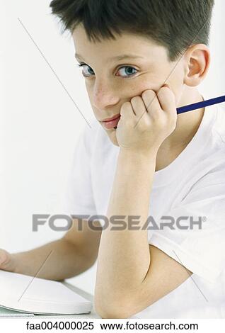 Boy sitting in front of homework, looking at camera View Large Photo Image Stock Photography - Boy sitting in front of homework, looking at camera. Fotosearch