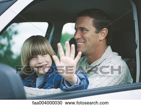 Boy sitting on father's lap in car View Large Photo Image Stock Image - Boy sitting on father's lap in car. Fotosearch