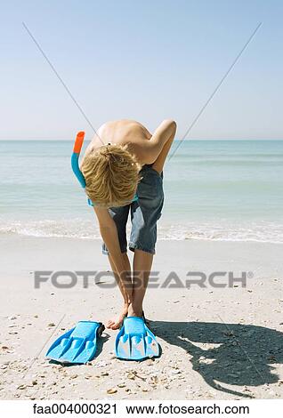 Boy wearing snorkel, putting on flippers View Large Photo Image Stock Image - Boy wearing snorkel, putting on flippers. Fotosearch