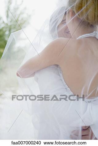Bride and groom embracing under veil View Large Photo Image Stock Image - Bride and groom embracing under veil. Fotosearch
