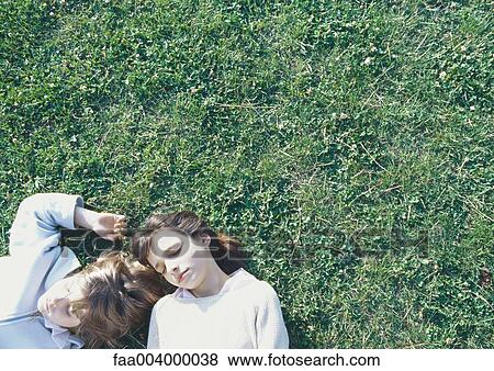 Stock Photo - Brother and sister taking nap on grass together. Fotosearch