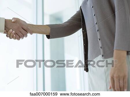 Business people shaking hands, mid section View Large Photo Image Stock Photo - Business people shaking hands, mid section. Fotosearch