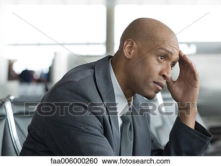 Business traveler holding head in airport lounge View Large Photo Image Stock Image - Business traveler holding head in airport lounge. Fotosearch