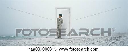 Businessman coming through doorway on beach View Large Photo Image Stock Photography - Businessman coming through doorway on beach. Fotosearch