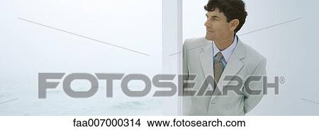 Businessman coming through doorway, sea in background View Large Photo Image Picture - Businessman coming through doorway, sea in background. Fotosearch
