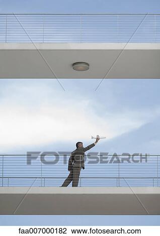 Businessman holding toy airplane View Large Photo Image Stock Image - Businessman holding toy airplane. Fotosearch