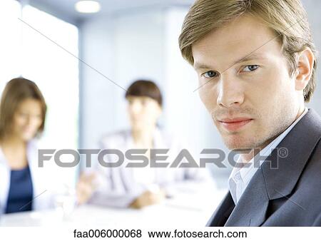 Businessman, meeting in background View Large Photo Image Stock Photo - Businessman, meeting in background. Fotosearch