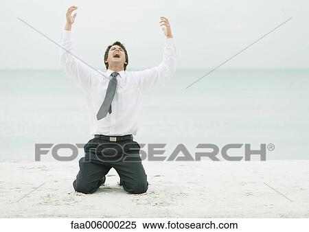 Businessman on beach, on knees with arms in air and head back View Large Photo Image Stock Photography - Businessman on beach, on knees with arms in air and head back. Fotosearch