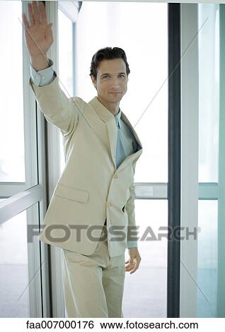Businessman standing by door, waving View Large Photo Image Stock Photograph - Businessman standing by door, waving. Fotosearch