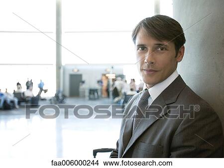 Businessman standing in airport, boarding gate in background View Large Photo Image Picture - Businessman standing in airport, boarding gate in background. Fotosearch