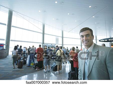Businessman standing in airport boarding area View Large Photo Image Stock Photo - Businessman standing in airport boarding area. Fotosearch