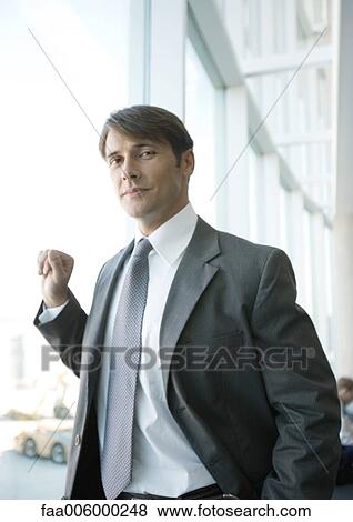 Businessman standing near glass wall View Large Photo Image Stock Photo - Businessman standing near glass wall. Fotosearch