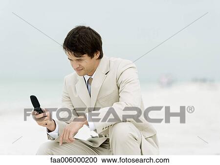 Businessman using cell phone on the beach View Large Photo Image Stock Image - Businessman using cell phone on the beach. Fotosearch
