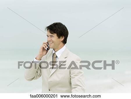 Businessman using cell phone on the beach View Large Photo Image Stock Image - Businessman using cell phone on the beach. Fotosearch