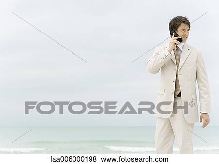 Businessman using cell phone on the beach View Large Photo Image Stock Photo - Businessman using cell phone on the beach. Fotosearch