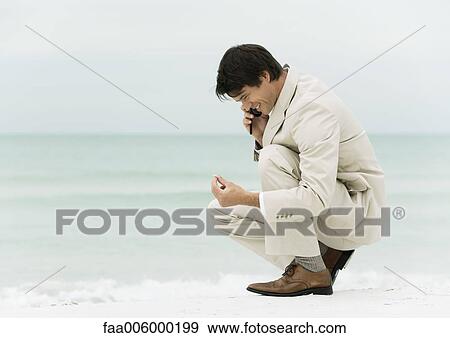 Businessman using cell phone on the beach View Large Photo Image Stock Photo - Businessman using cell phone on the beach. Fotosearch