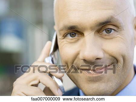 Businessman using cell phone, smiling View Large Photo Image Stock Photo - Businessman using cell phone, smiling. Fotosearch
