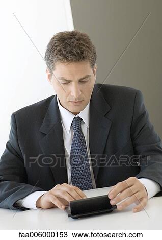 Businessman using pocket computer View Large Photo Image Stock Image - Businessman using pocket computer. Fotosearch