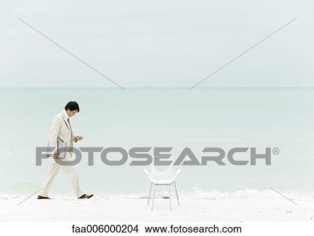 Businessman walking on beach View Large Photo Image Picture - Businessman walking on beach. Fotosearch