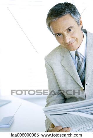 Businessman with newspaper, smiling at camera View Large Photo Image Stock Photography - Businessman with newspaper, smiling at camera. Fotosearch