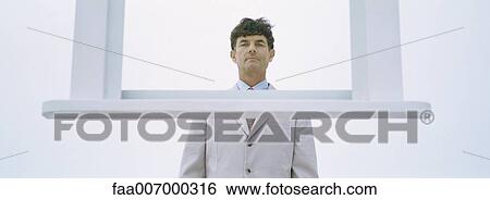 Businessman with upside down table hanging in front of him View Large Photo Image Stock Photograph - Businessman with upside down table hanging in front of him. Fotosearch