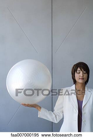 Businesswoman balancing white ball on palm of hand, eyes closed View Large Photo Image Stock Photography - Businesswoman balancing white ball on palm of hand, eyes closed. Fotosearch