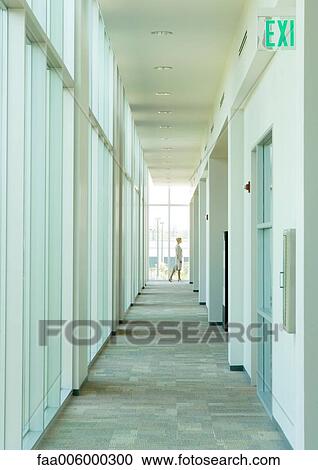 Businesswoman in distance at end of corridor in office building View Large Photo Image Stock Image - Businesswoman in distance at end of corridor in office building. Fotosearch