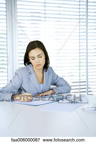 Businesswoman signing documents at desk View Large Photo Image Stock Photo - Businesswoman signing documents at desk. Fotosearch