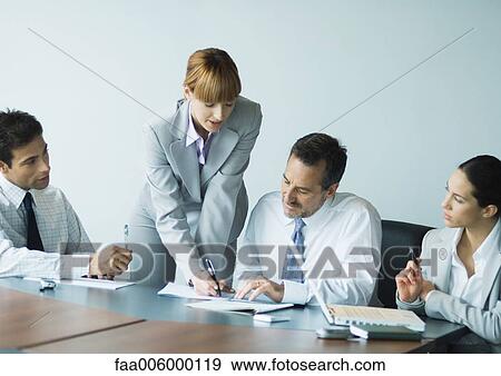 Businesswoman standing, speaking to seated colleagues View Large Photo Image Stock Photo - Businesswoman standing, speaking to seated colleagues. Fotosearch