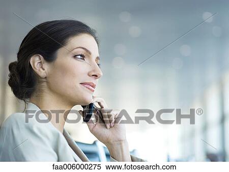 Stock Photography - Businesswoman using cell phone, low angle view. Fotosearch