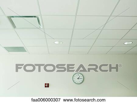 Stock Photo - Clock on wall in office space. Fotosearch