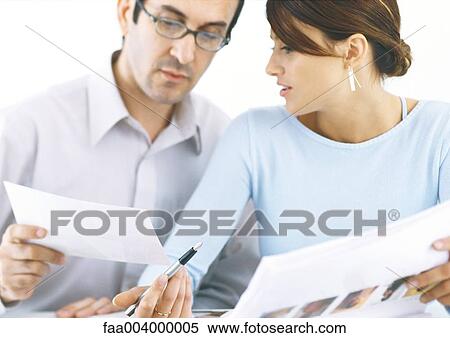 Colleagues looking at documents View Large Photo Image Stock Photography - Colleagues looking at documents. Fotosearch