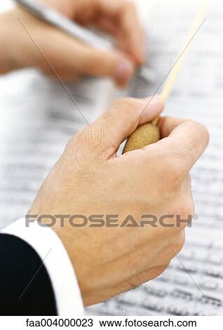 Conductor taking notes on sheet music View Large Photo Image Stock Image - Conductor taking notes on sheet music. Fotosearch