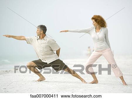 Couple doing relaxation exercises together on beach View Large Photo Image Stock Image - Couple doing relaxation exercises together on beach. Fotosearch