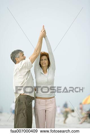 Couple doing relaxation exercises together on beach View Large Photo Image Stock Photo - Couple doing relaxation exercises together on beach. Fotosearch