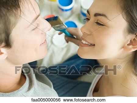 Couple face to face with painting materials in background View Large Photo Image Stock Photograph - Couple face to face with painting materials in background. Fotosearch