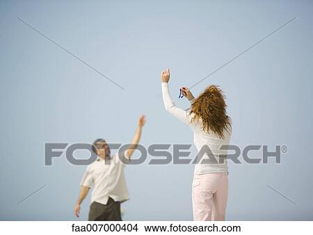 Picture - Couple flying kite. Fotosearch
