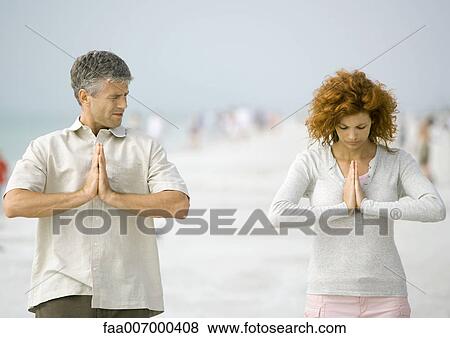 Stock Photo - Couple meditating on beach. Fotosearch