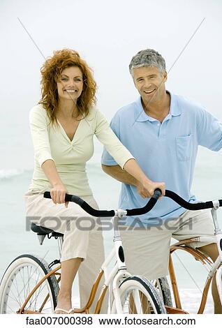 Couple riding bikes on beach View Large Photo Image Stock Photo - Couple riding bikes on beach. Fotosearch