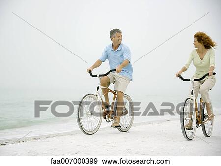 Couple riding bikes on beach View Large Photo Image Stock Photo - Couple riding bikes on beach. Fotosearch