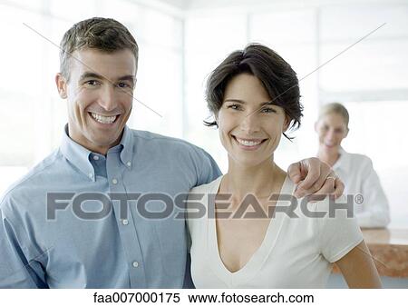 Stock Photography - Couple smiling, reception desk in background. Fotosearch