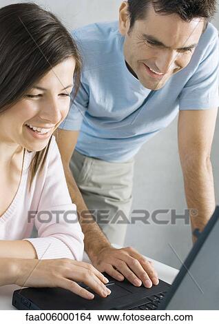 Couple using laptop together View Large Photo Image Picture - Couple using laptop together. Fotosearch