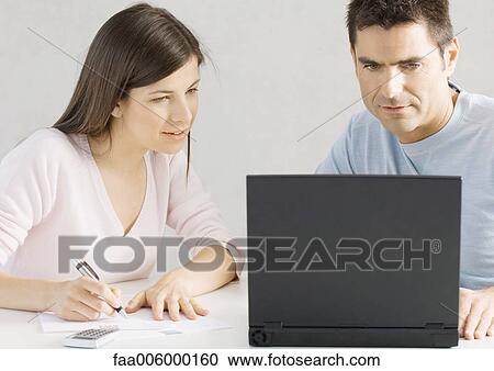 Stock Image - Couple using laptop together. Fotosearch