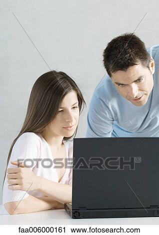Stock Image - Couple using laptop together. Fotosearch