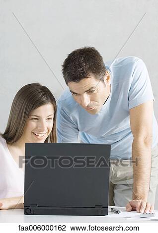 Couple using laptop together View Large Photo Image Stock Image - Couple using laptop together. Fotosearch
