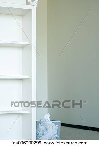 Crumpled paper on top of bookcase next to full wastebasket View Large Photo Image Stock Photo - Crumpled paper on top of bookcase next to full wastebasket. Fotosearch