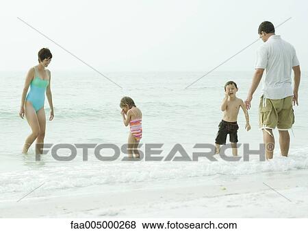 Stock Photo - Family at the beach, standing in water. Fotosearch