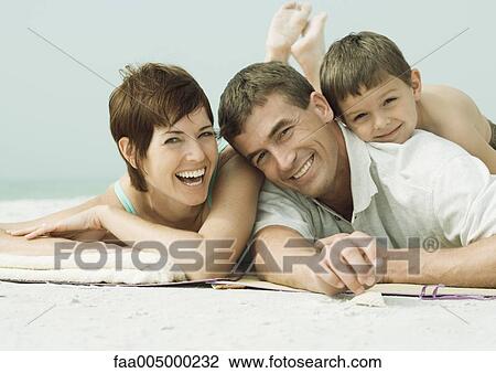 Family lying on beach, smiling, portrait View Large Photo Image Stock Image - Family lying on beach, smiling, portrait. Fotosearch